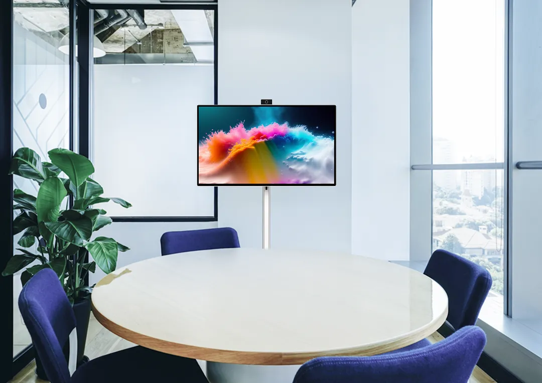 丸テーブルと4脚の椅子が配置されたガラス張りの小会議室に、スタンド型ディスプレイが設置されている。