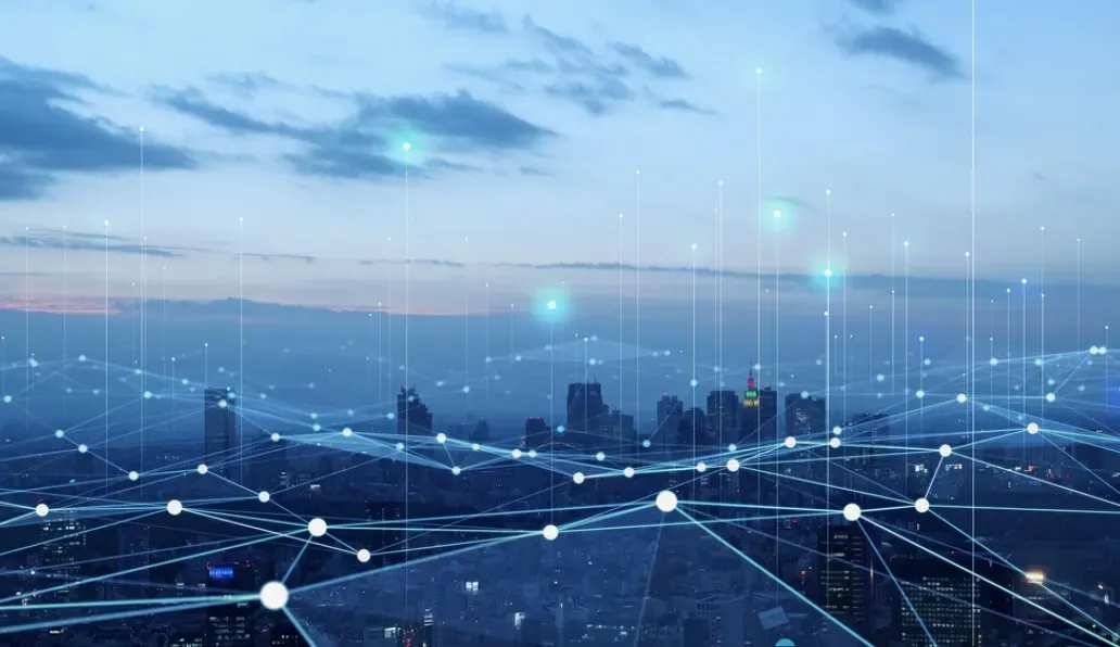 都市の夜景にデジタルネットワークを重ねたイメージ、通信やIoTの概念を表現